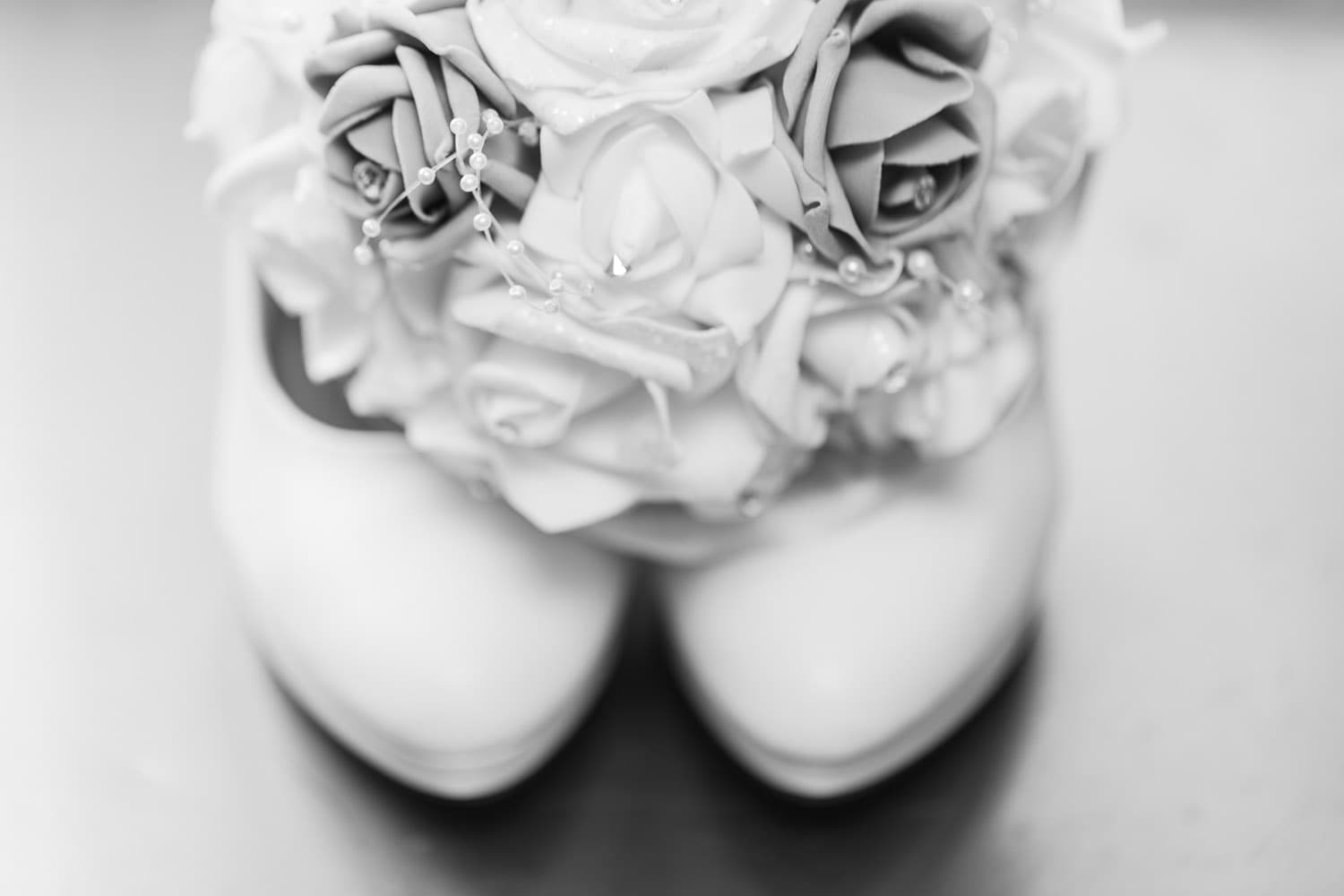 macro photography of brides shoes and boquet