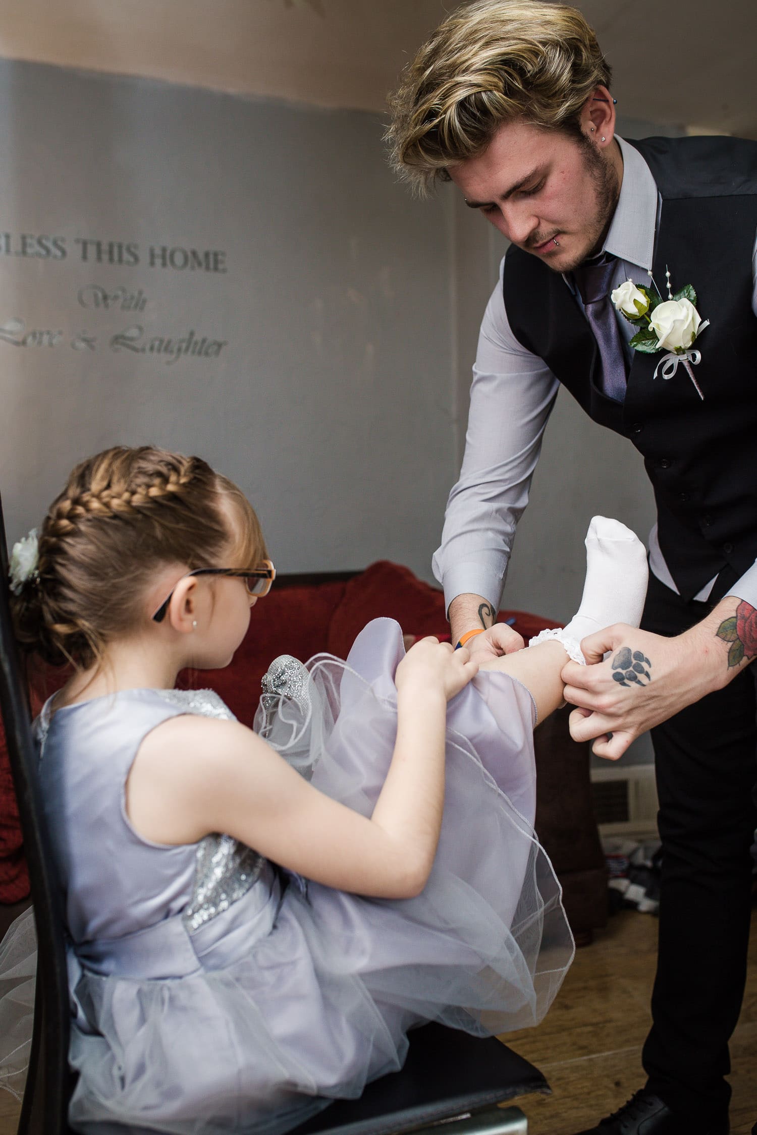 best man putting on flower girls shoes