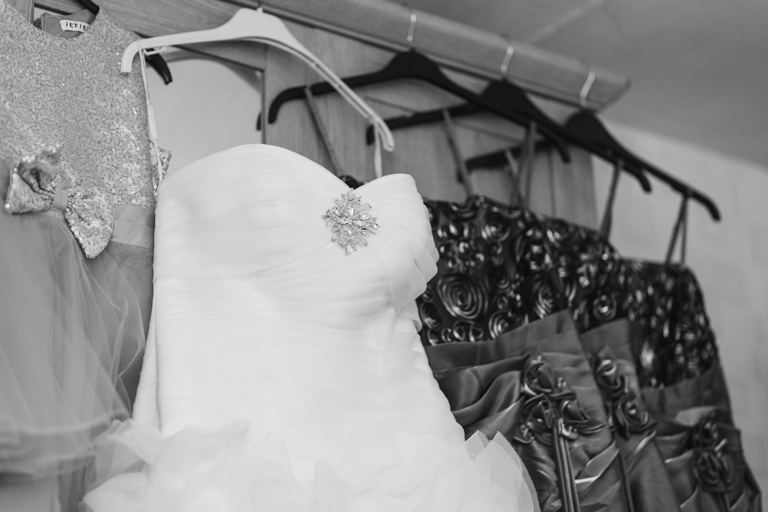 wedding dress hangs on cupboard ready to be worn