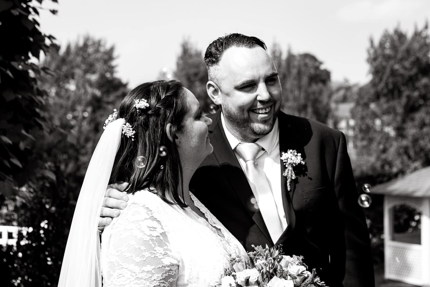 bride and groom put arms around each other during warwick house wedding