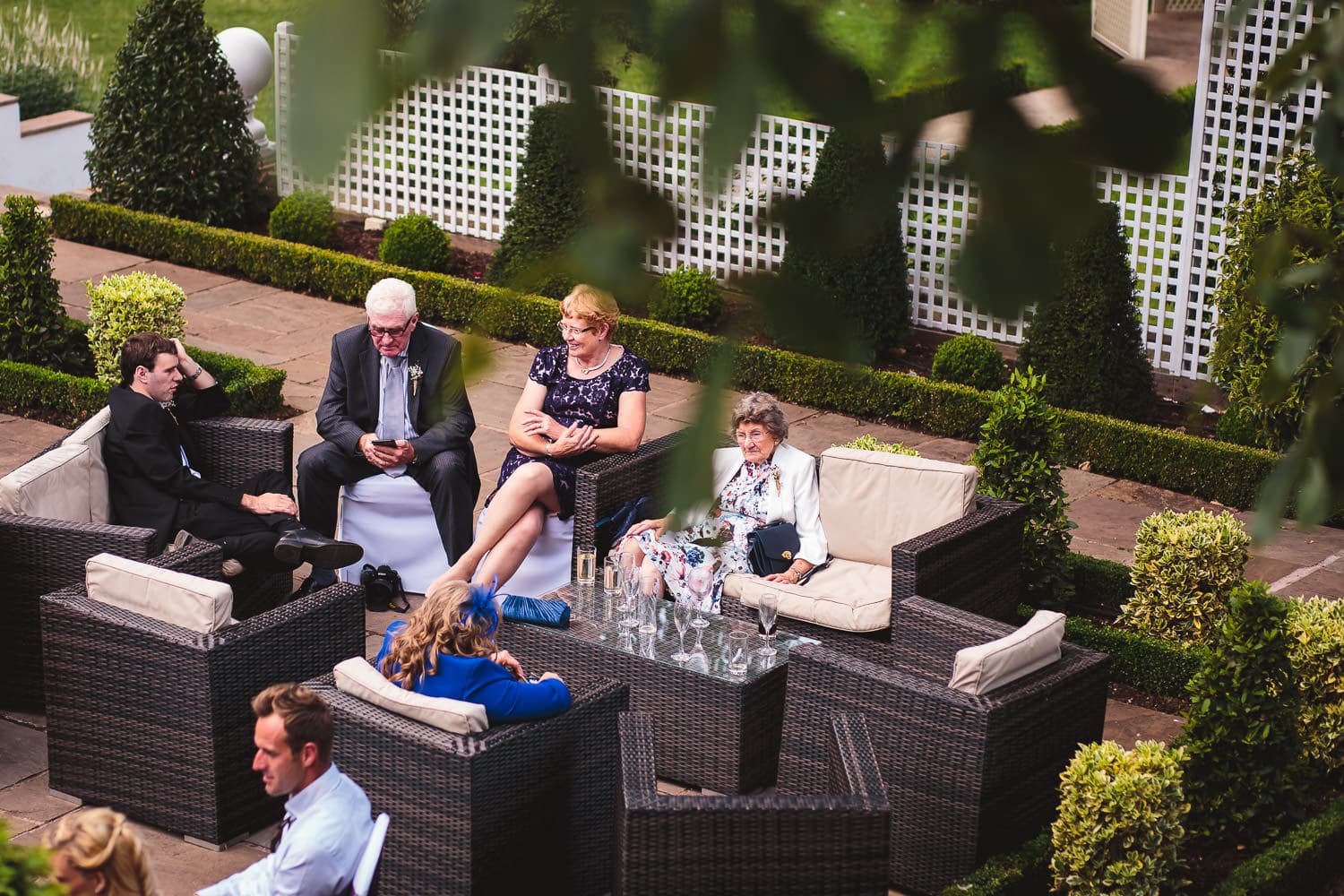 evening guests sit on terrace at warwick house wedding venue