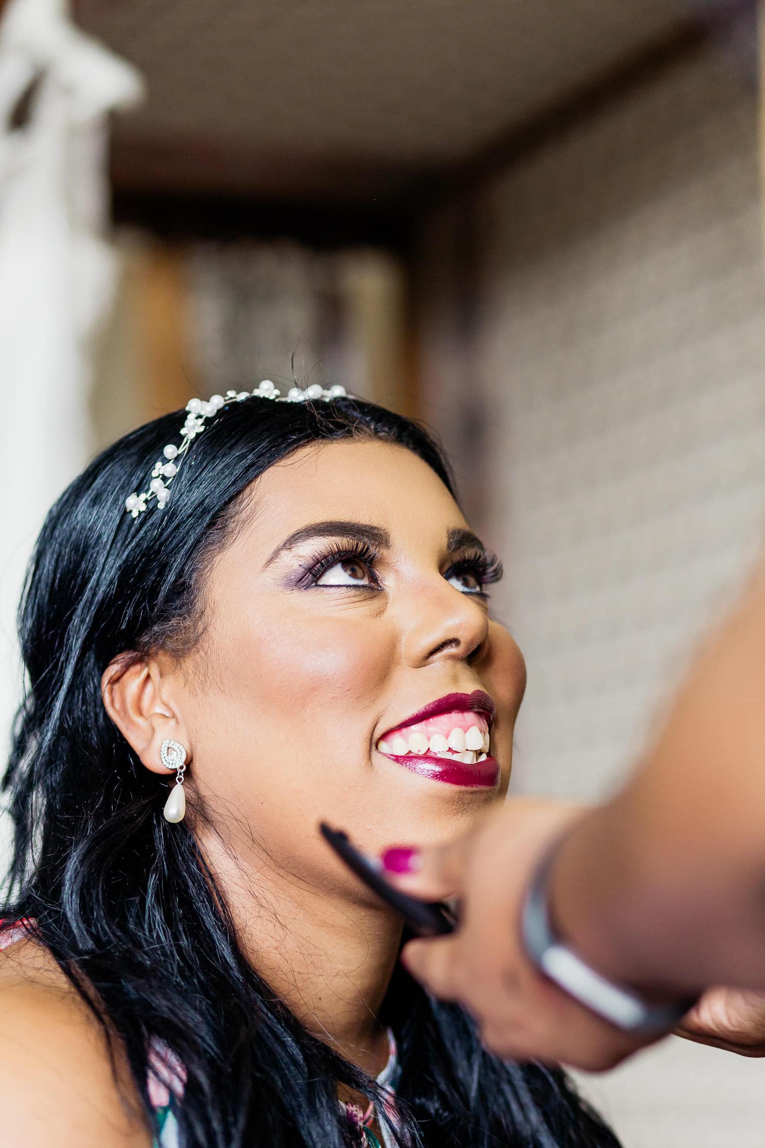 bride smiling at makeup artist