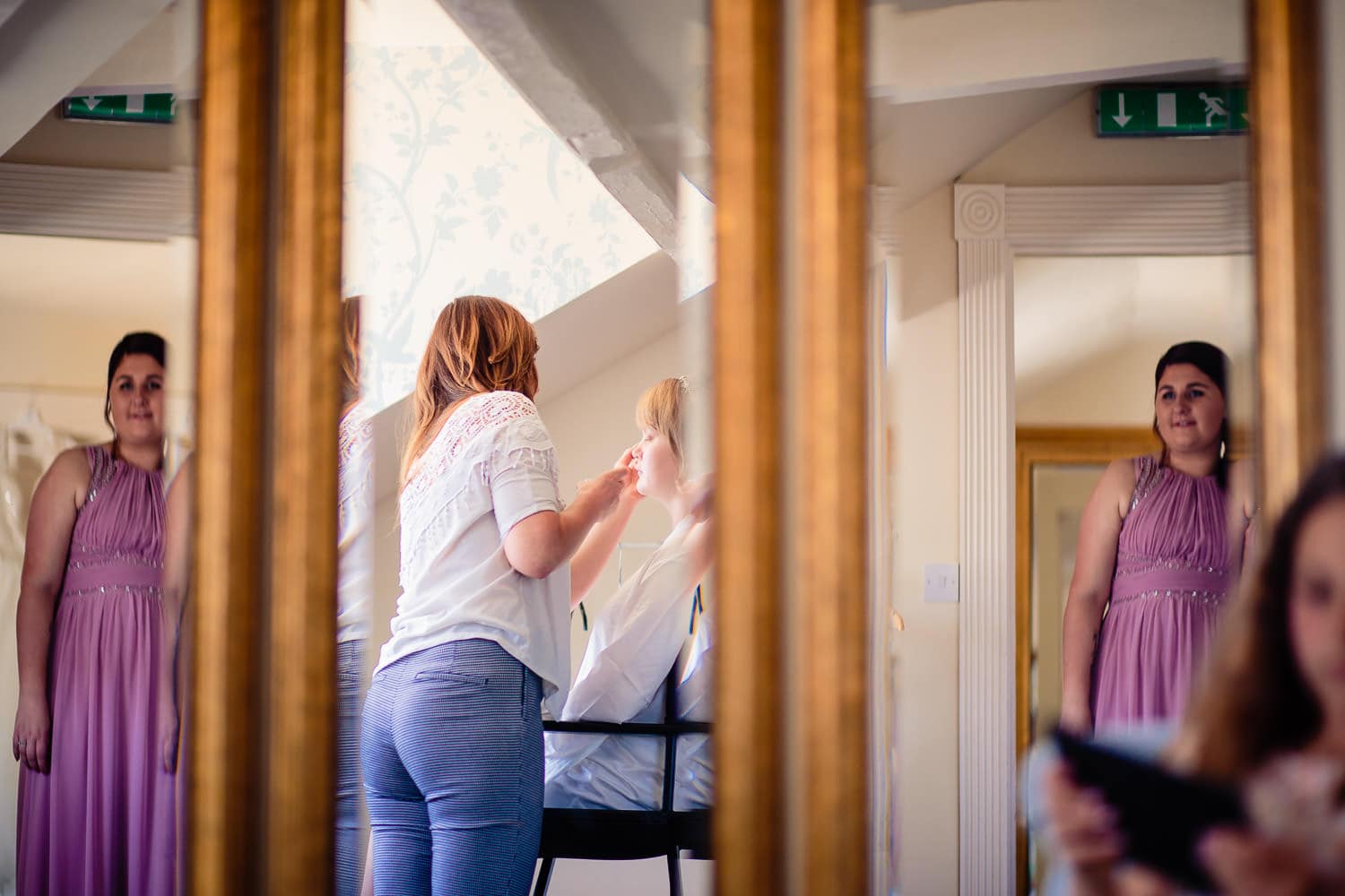 Clever Warwick House Wedding Photography captures reflection of bridesmaid in mirror during preparationss