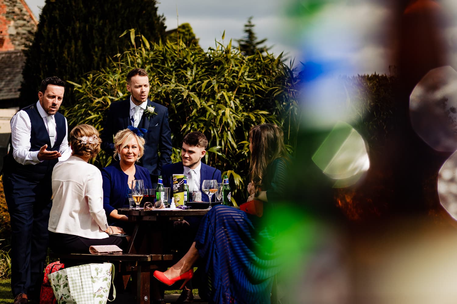 Wedding guests relax in the sunshine during amazing Leicestershire wedding reception