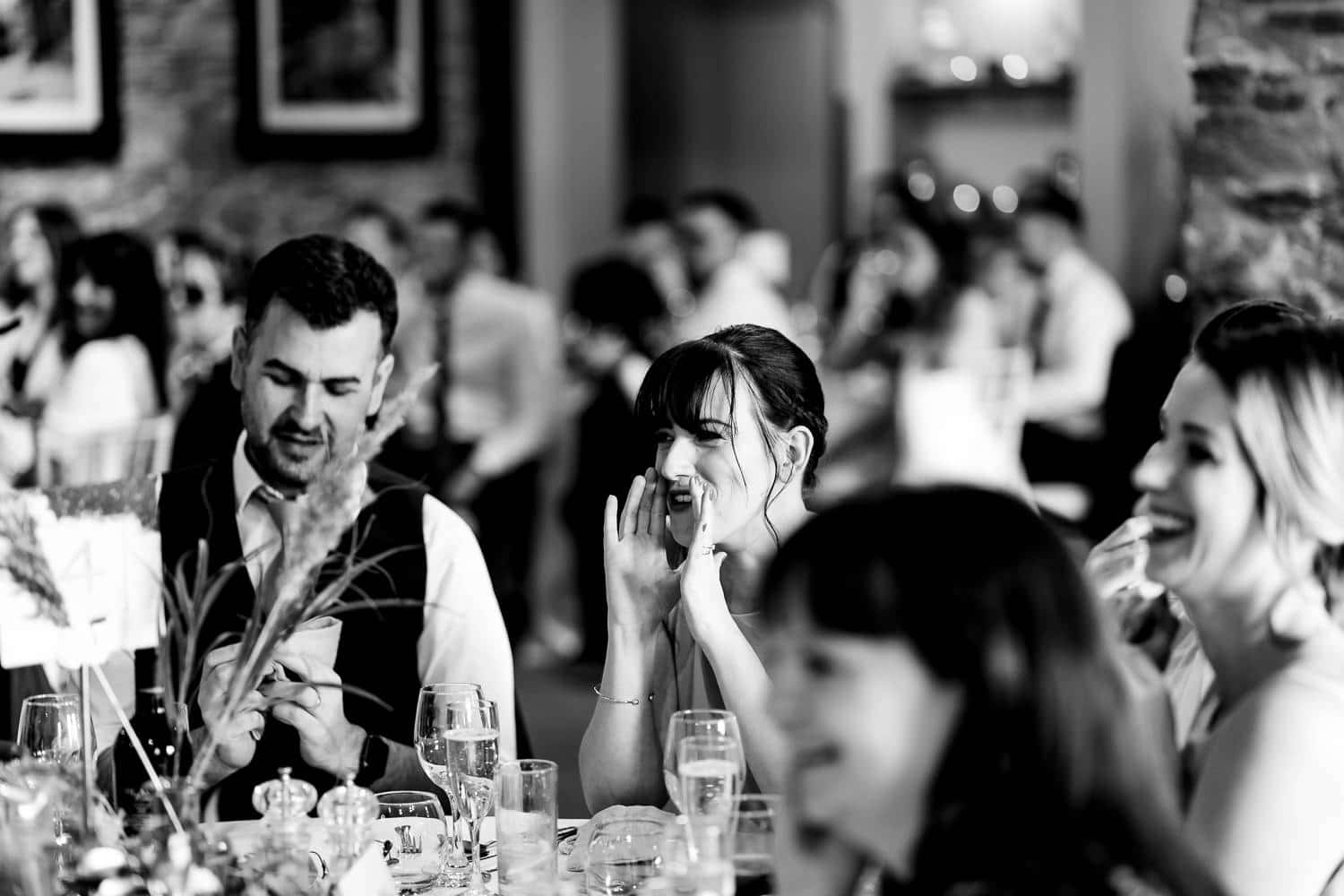 Wedding guests laugh during speeches at The Old Stables Swithland