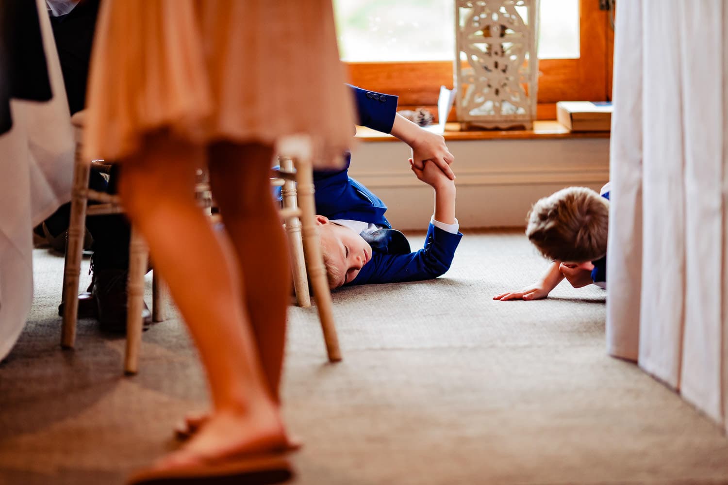 Children rolling on the floor during wedding reception at the Griffin Inn Swithland