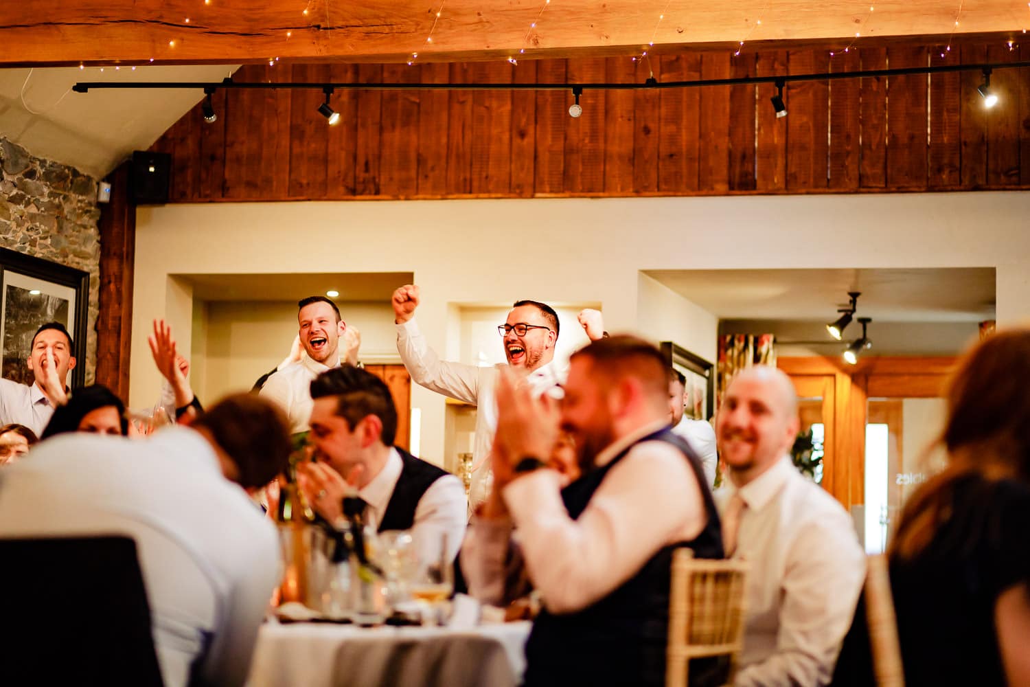 Wedding guests cheer and laugh during wedding reception bingo